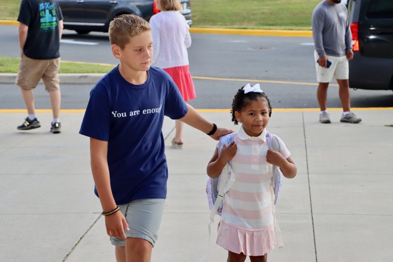 Fifth-grader Max Bradshaw, left, helps escort younger students into the building on their first day of school. BILL SHULL PHOTO